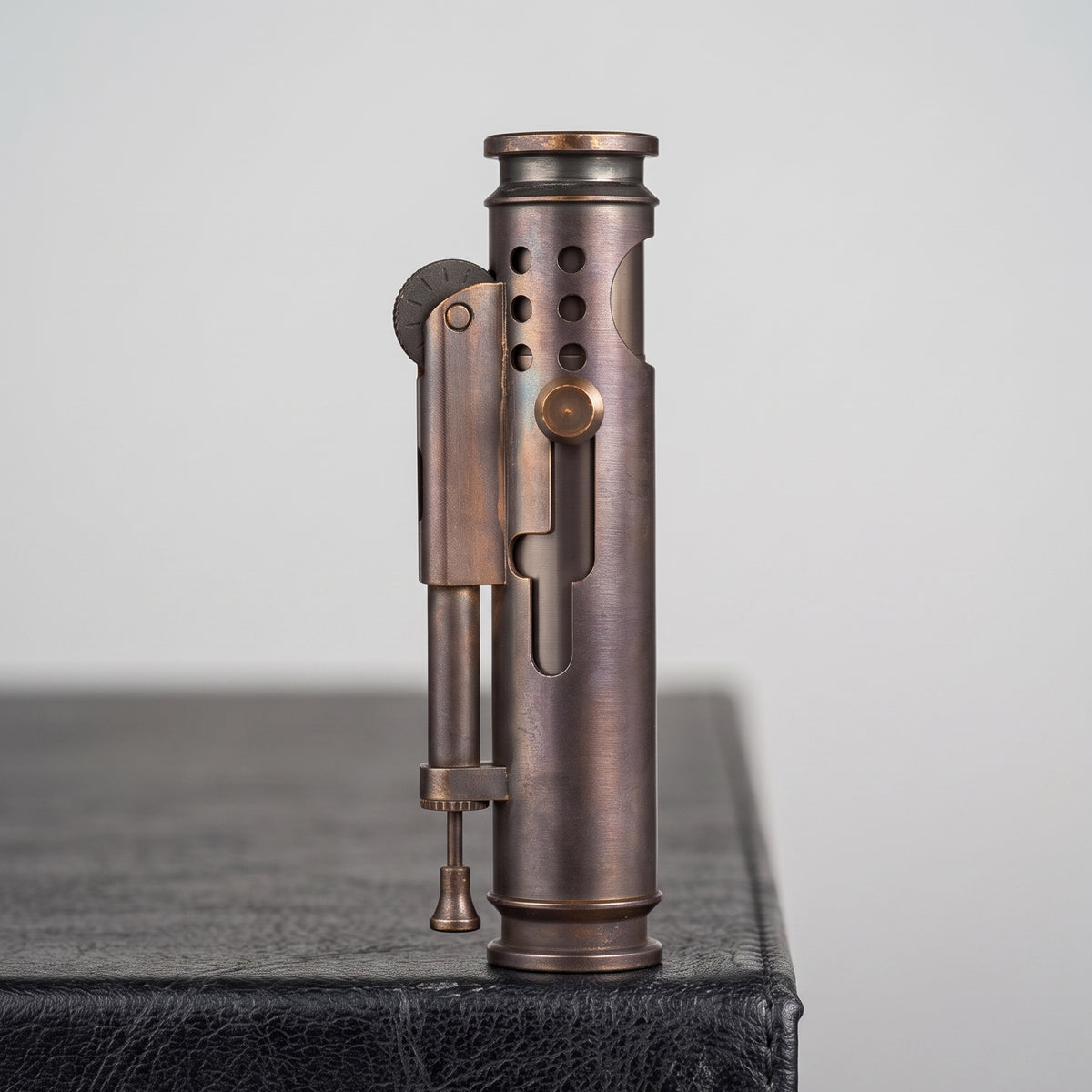 Glossy Thorens Battle Soul trench lighter standing upright on a dark leather surface with a warm wood background