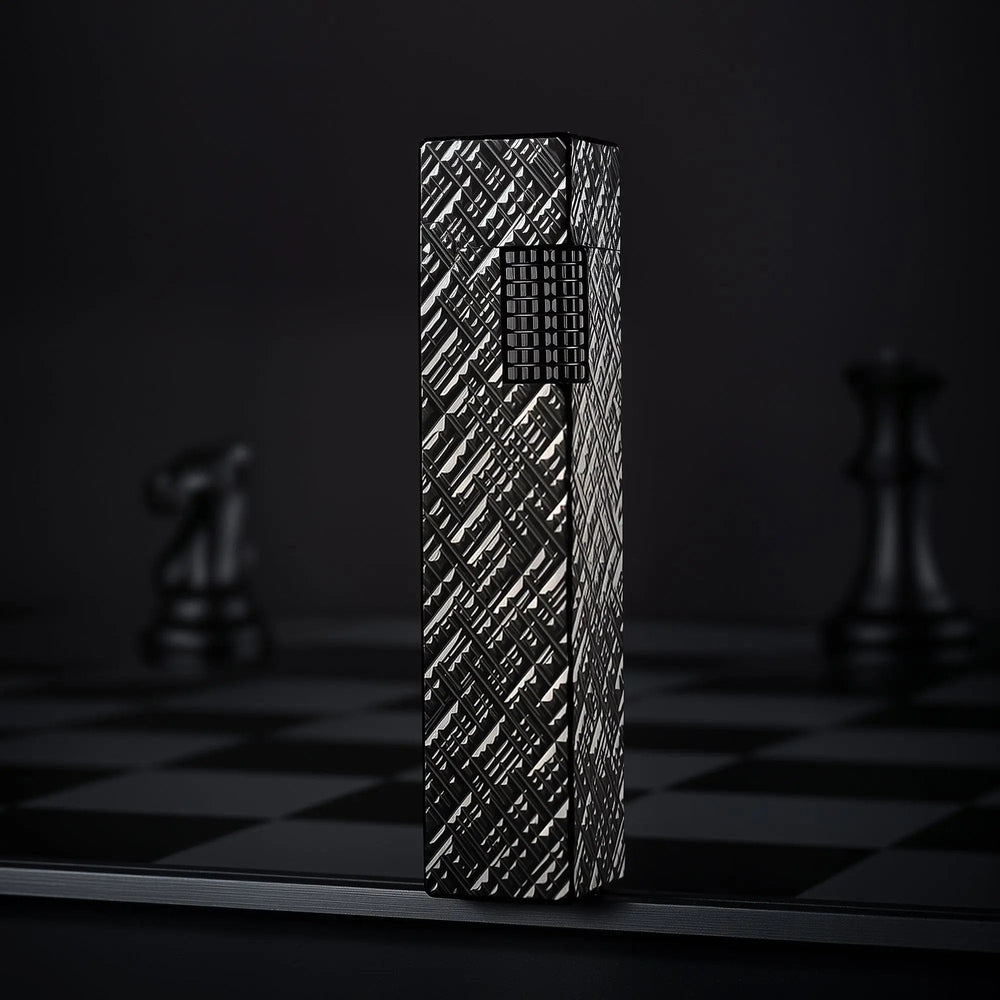 Black carved Thorens rectangular side-slip lighter standing upright in the closed position, featuring an engraved geometric texture and exposed side ignition wheel against a dark checkered background