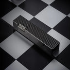Black small square textured Thorens side-slip rectangular lighter placed on a black and white checkerboard surface