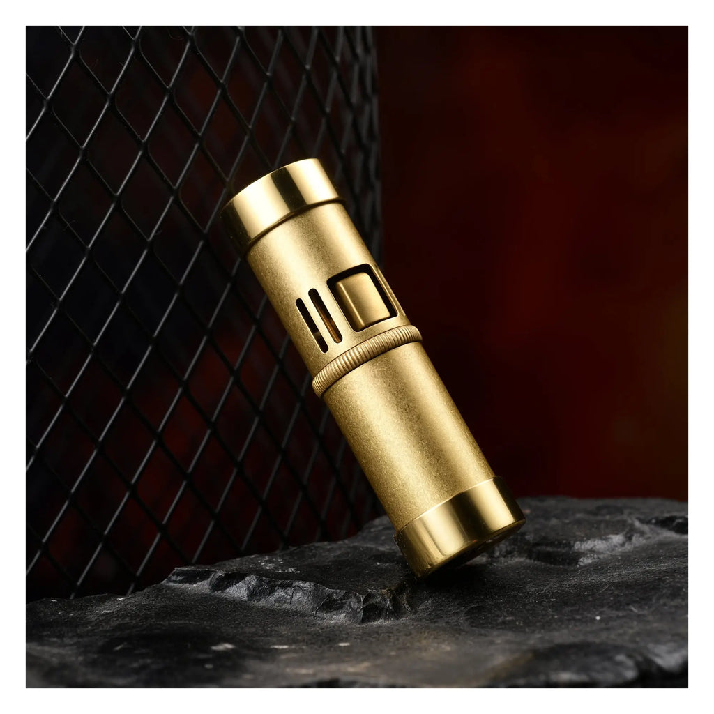 A Thorens Blaze Capsule lighter in a weathered vintage brass finish, featuring a distinctive cylindrical body and tactile vertical ribbing for refined EDC aesthetics and mechanical reliability.