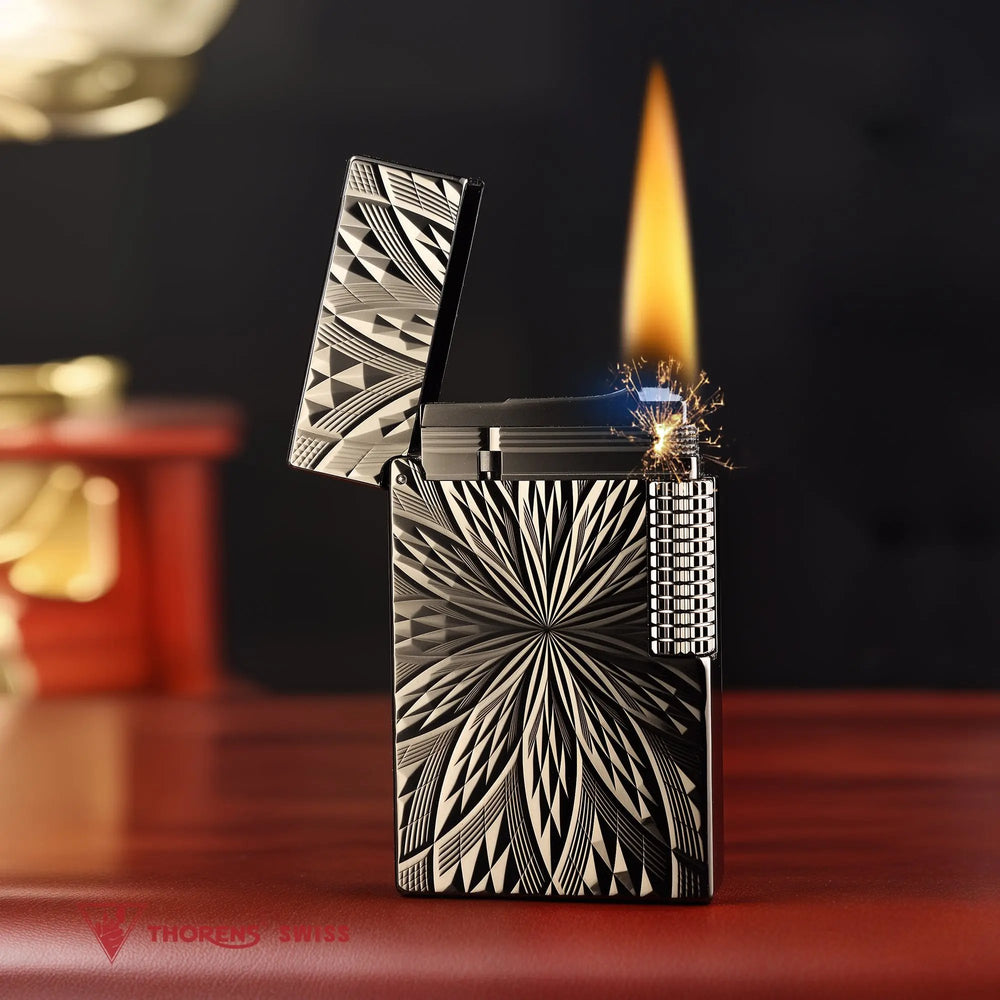 An ignited Blooming Radiance black lighter with an open lid, showing a vibrant flame and mechanical sparks against the dark, floral-engraved brass body.