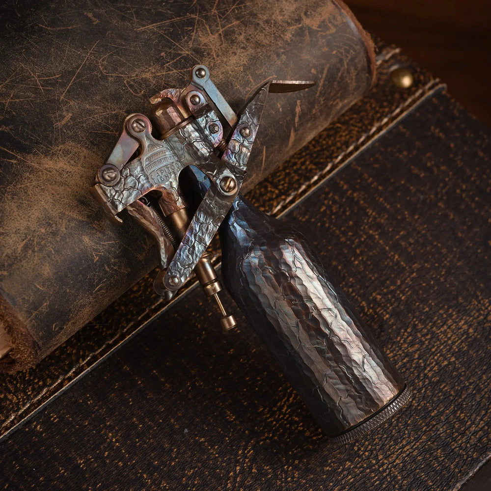 A Capitol Table Lighter featuring unique hand-carved crack patterns on a weathered brass body, resting on a leather-textured surface to highlight its artisan craftsmanship.