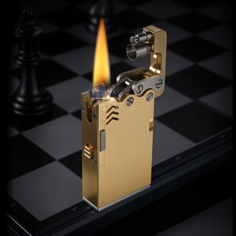 Thorens Ejection Lighter in brushed brass finish igniting with visible spark and flame, lid open to reveal exposed mechanical ignition assembly.