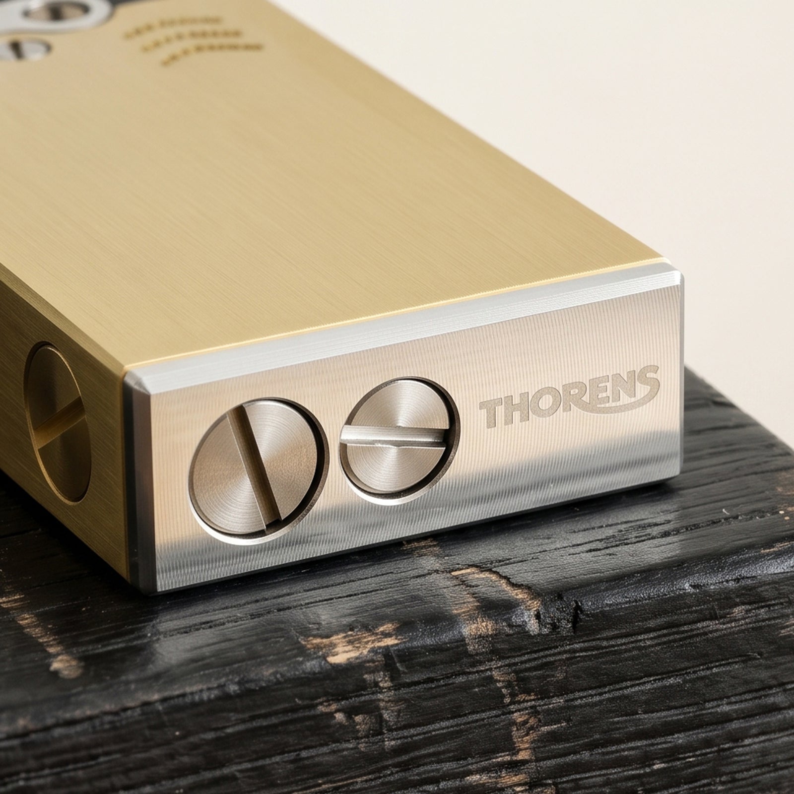 Thorens Ejection Lighter in brushed brass finish shown closed on a chessboard surface, highlighting side ignition slider and precision mechanical components.