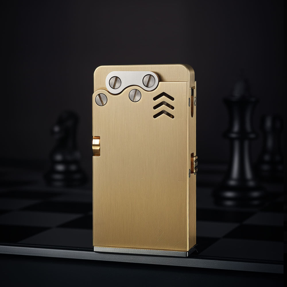 Thorens Ejection Lighter in brushed brass standing upright on a chessboard surface, highlighting engraved vents and exposed mechanical screw plate.