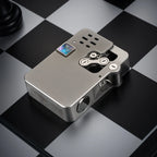 A brushed metal Ejection Lighter with a hollowing machine design, showcasing intricate mechanical linkages and a colorful inlay on a chessboard.