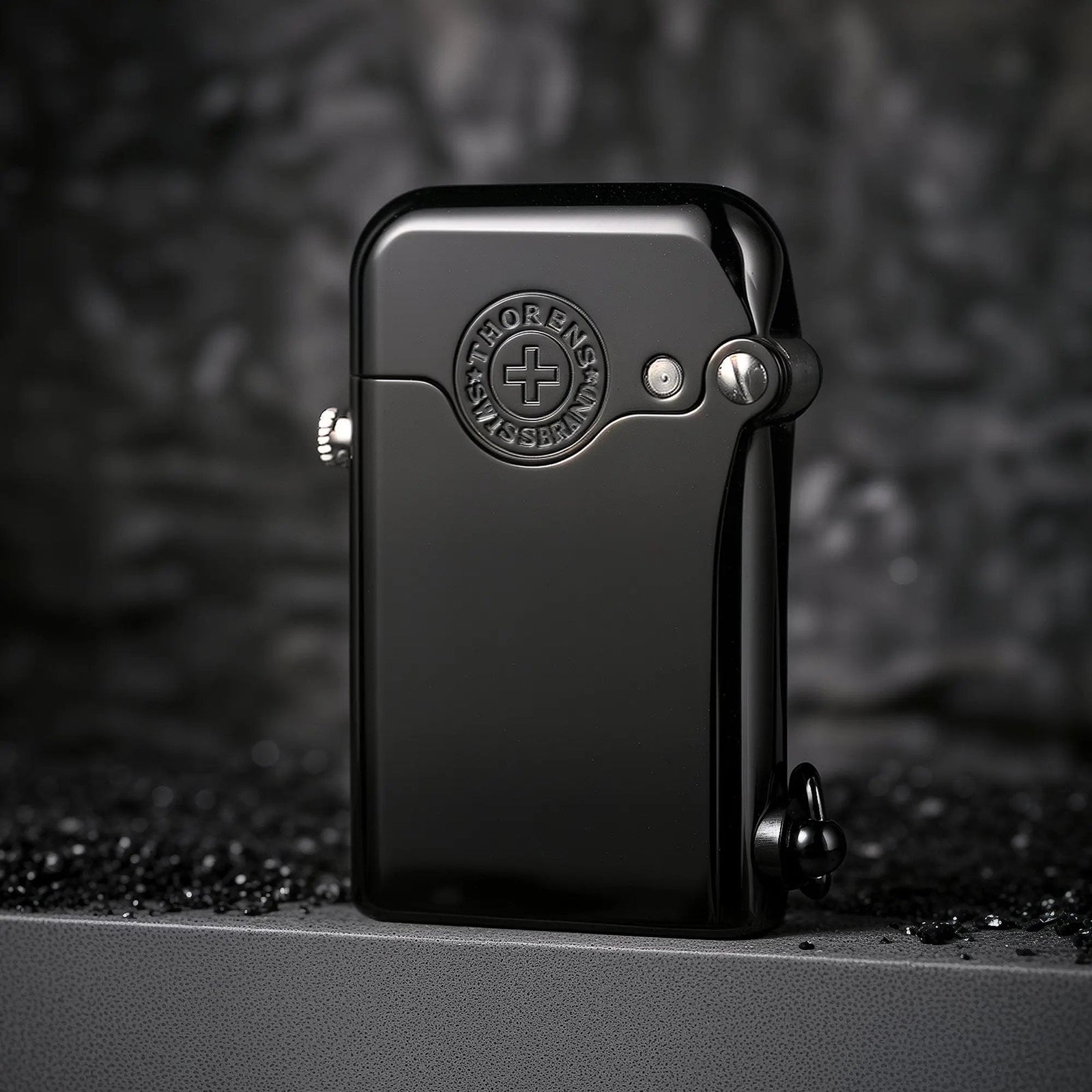 A glossy black Gen 1 Single Claw lighter featuring a prominent embossed Thorens Swiss Brand emblem on the body and high-precision mechanical fasteners.