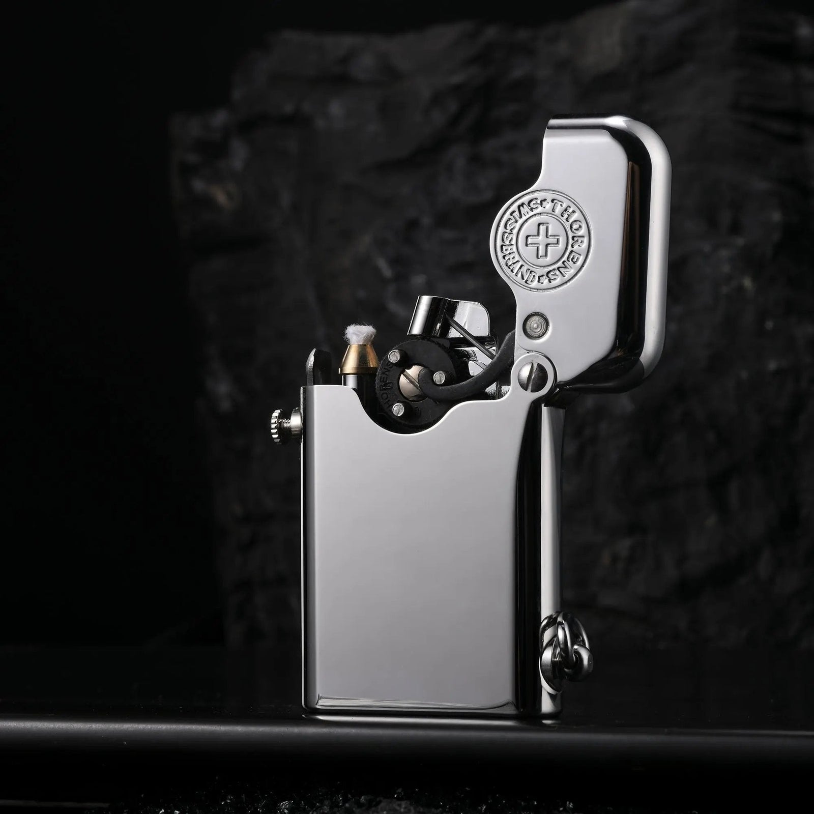 An open Thorens Gen 1 Single Claw silver lighter with a polished glossy finish, featuring the iconic Swiss heritage brand emblem inside the lid and a detailed mechanical claw structure.