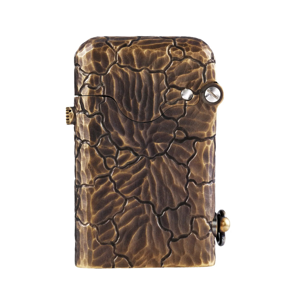 A Gen 1 Single Claw lighter featuring a rugged hand-carved earth fissure texture with a deep-etched cracked stone effect on an antique brass body.