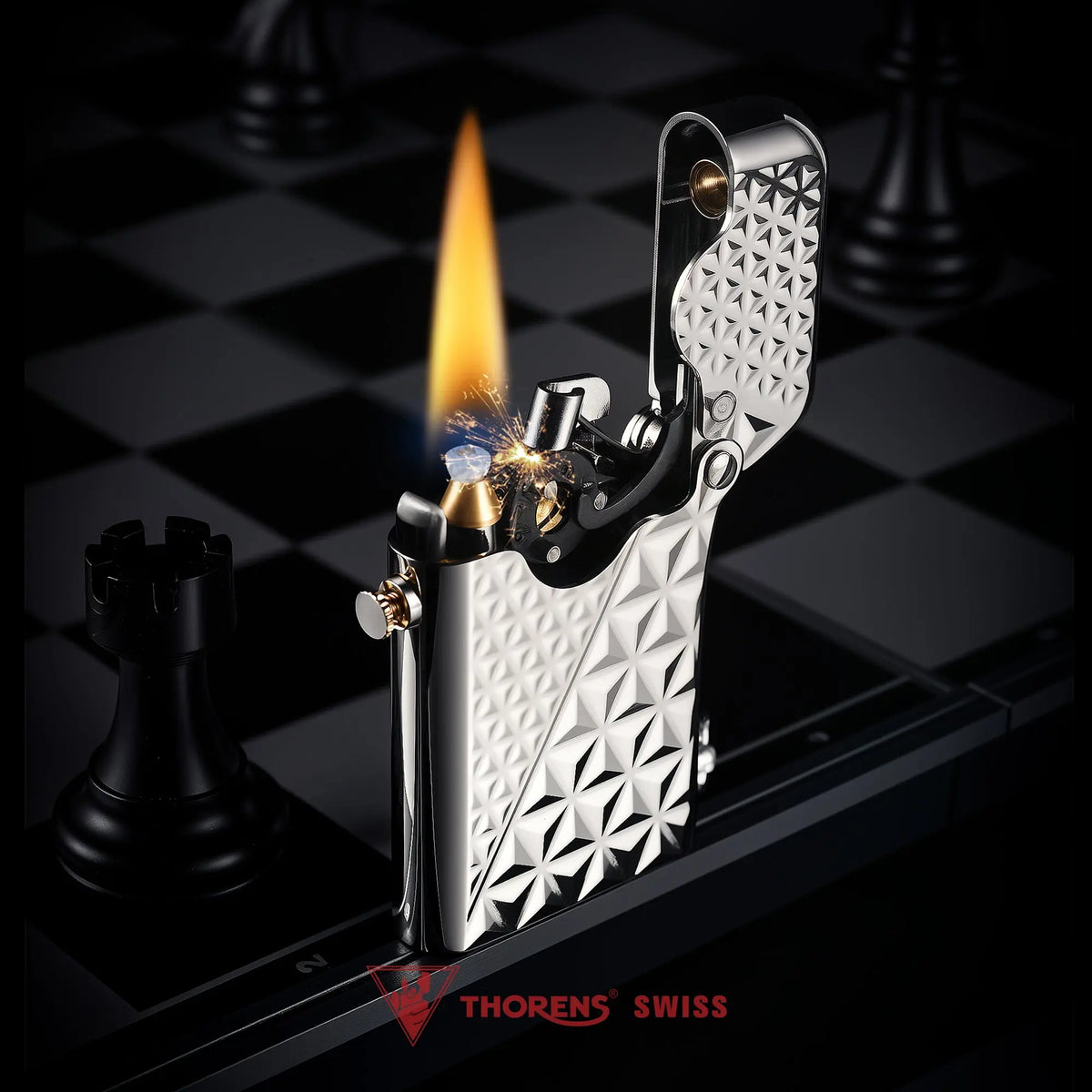 A silver Thorens Gen 1 single claw lighter ignited, showing the vibrant flame and internal flint sparks against a geometric diamond pattern.