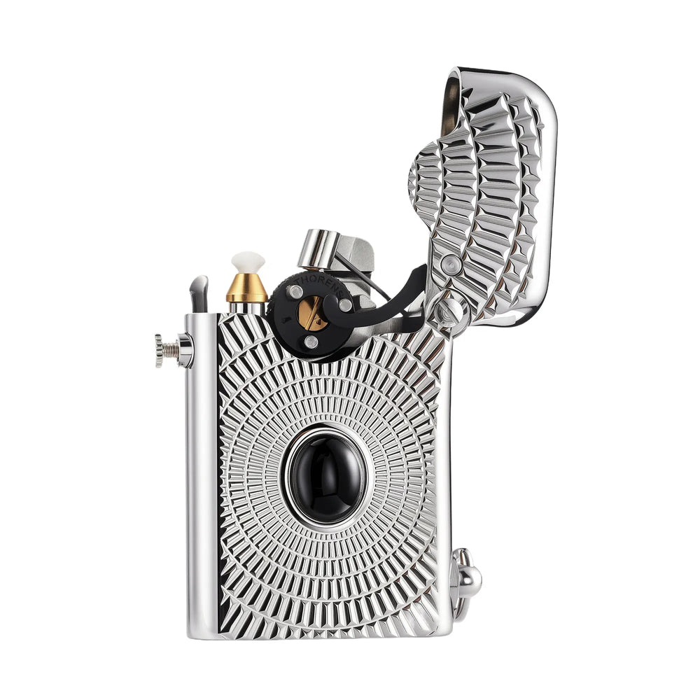 An open silver Thorens Gen 1 single claw lighter featuring a sunburst radial engraving centered on a black cabochon, highlighting the mechanical interior and the textured inner lid.