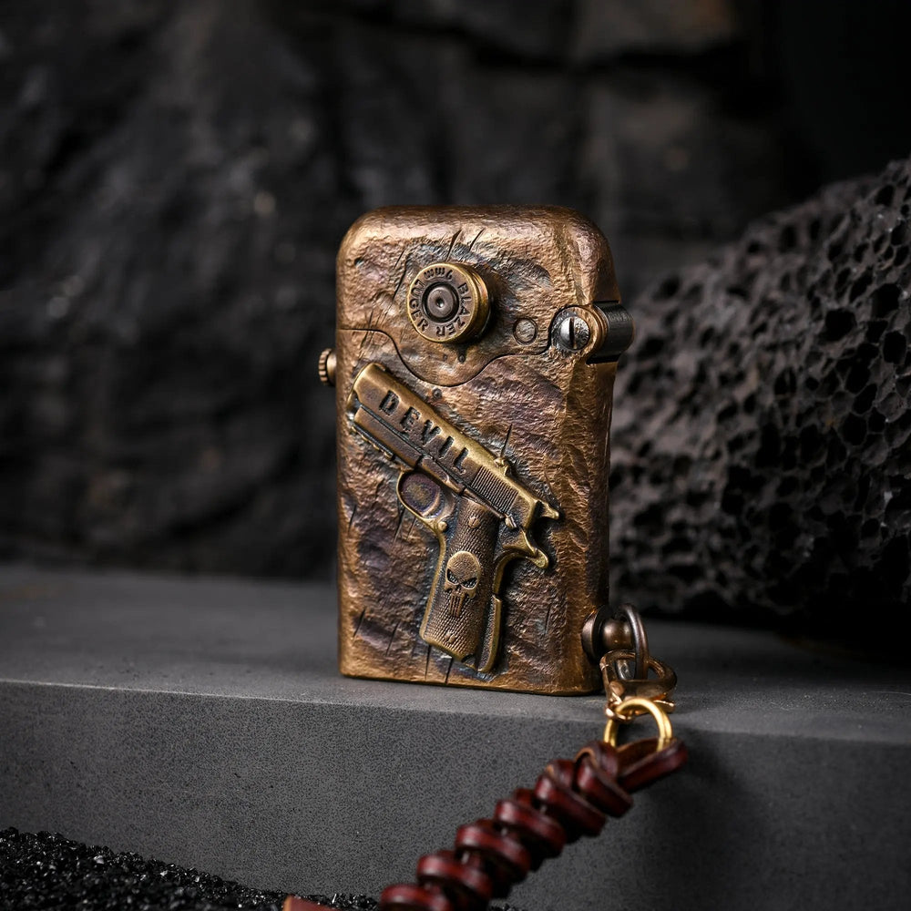 Hand-carved brass Thorens lighter featuring a 1911 pistol relief and Punisher skull detail, displayed on a dark volcanic rock background.