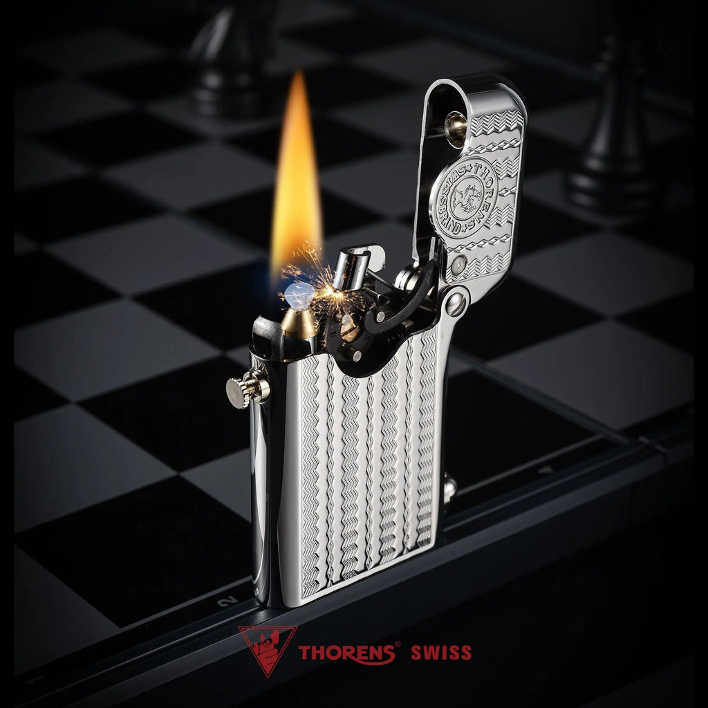 A silver Gen 1 Single Claw lighter with a water ripple engraving shown ignited with a steady flame and sparks on a professional chessboard background.