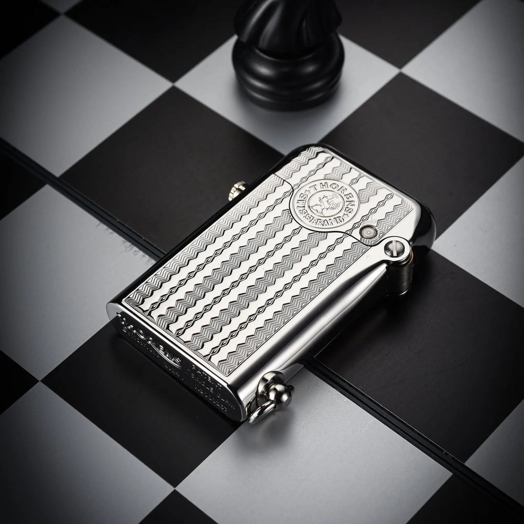 A polished silver Gen 1 Single Claw lighter featuring a textured water ripple engraving and bottom brand stamping, resting on a checkered surface.