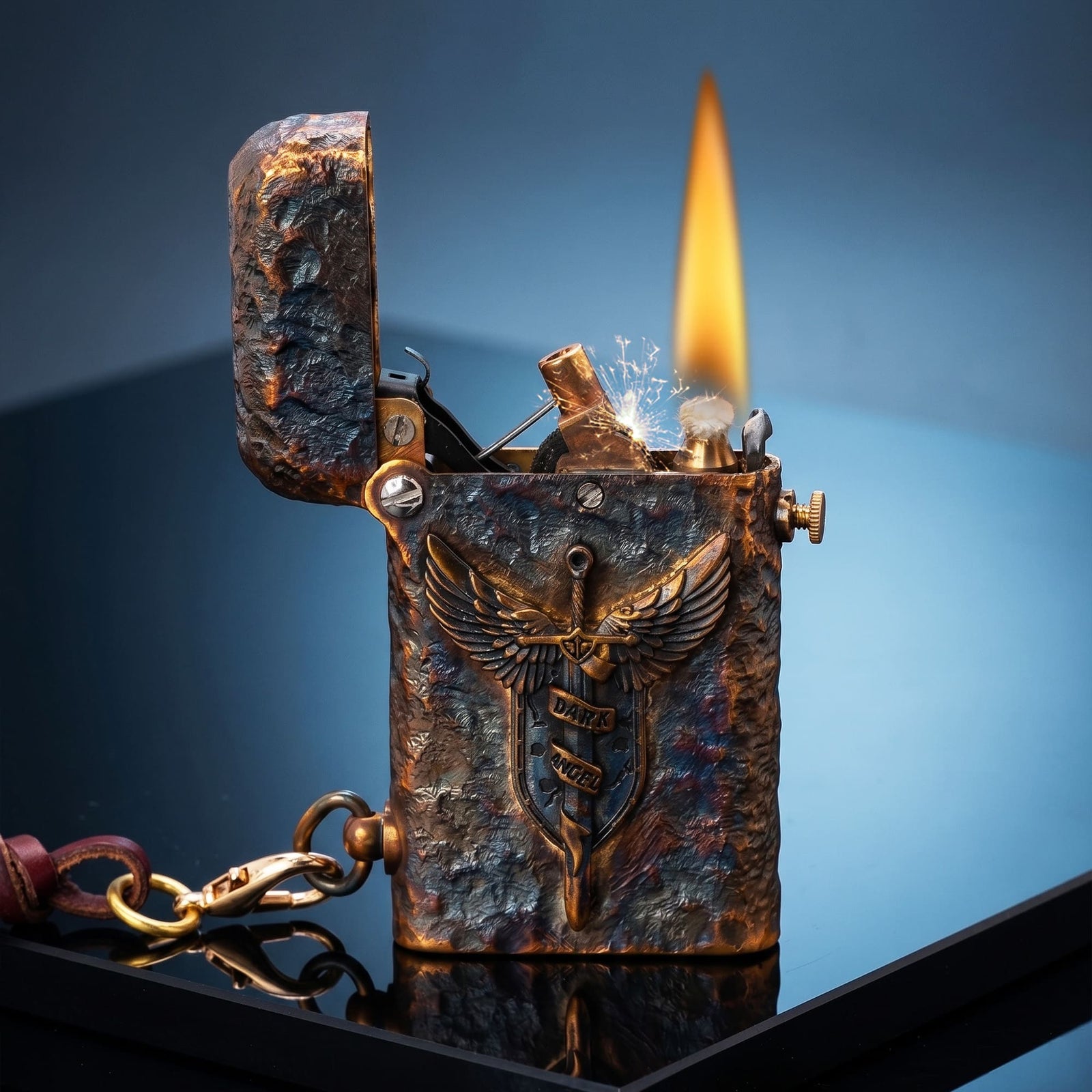 Thorens Gen 2 Double Claw Dark Angel Blade lighter shown open and ignited, highlighting the winged blade emblem, exposed mechanism, distressed brass finish, and side leather charm.