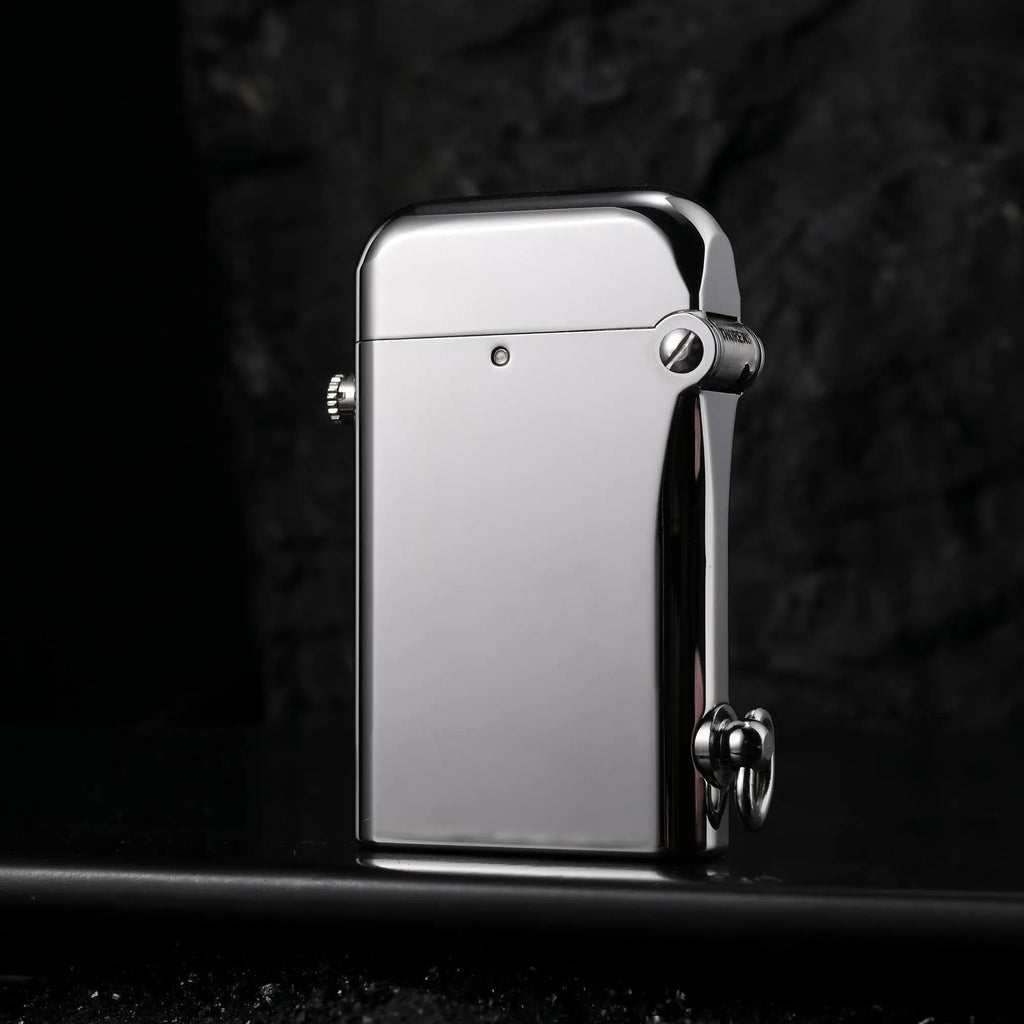 A Thorens Gen 2 Double Claw silver lighter with a mirror-polished glossy finish, standing against a dark stone background with a sleek reflection.