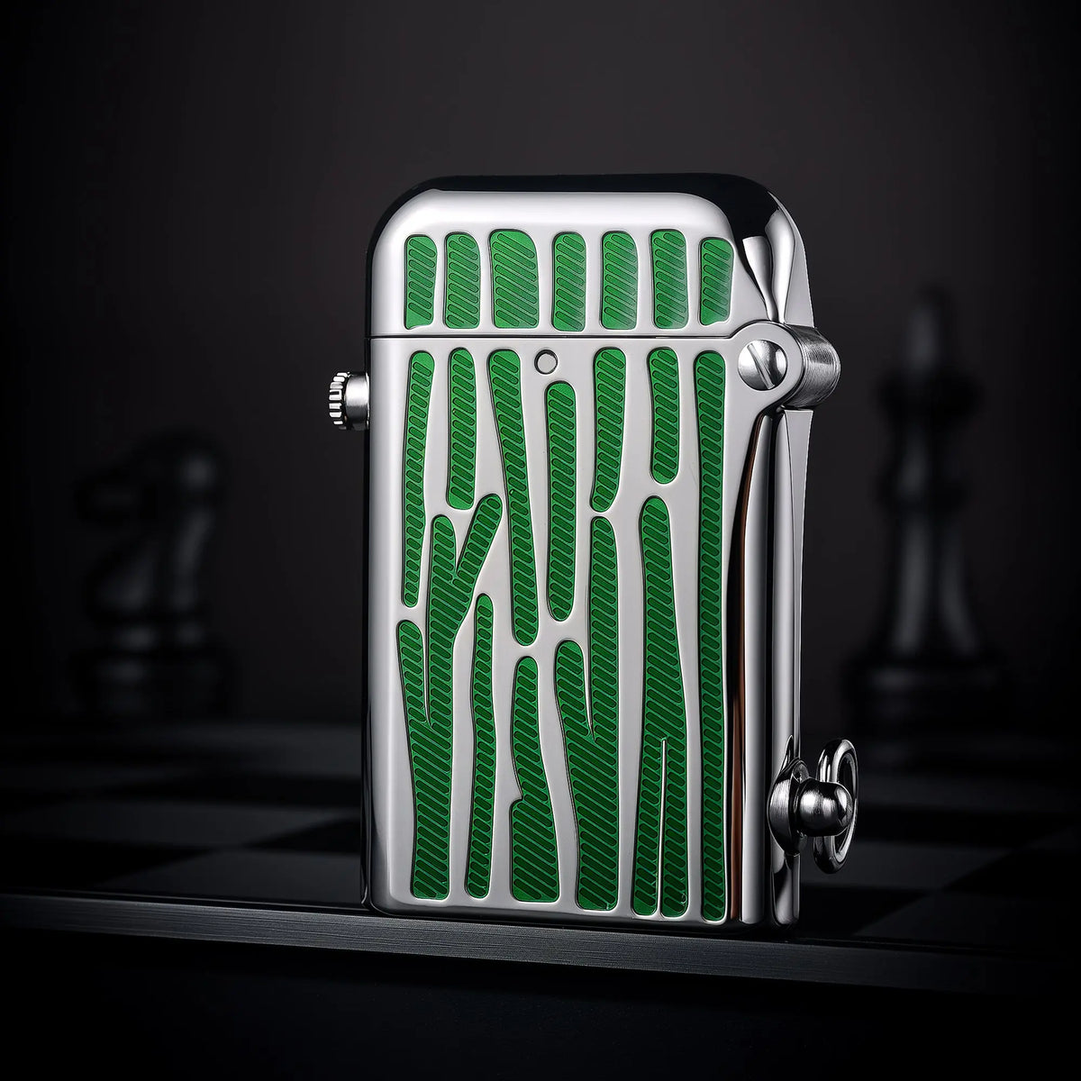 A closed silver Gen 2 Double Claw lighter standing upright, featuring vibrant green striped enamel inlays and a high-polish chassis against a moody chessboard background.