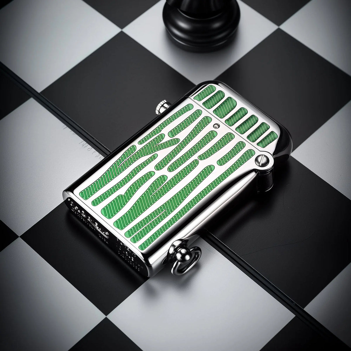 A silver Gen 2 Double Claw lighter featuring recessed green striped enamel inlays on a chessboard background, showing the side-ignition button and bottom lanyard loop.