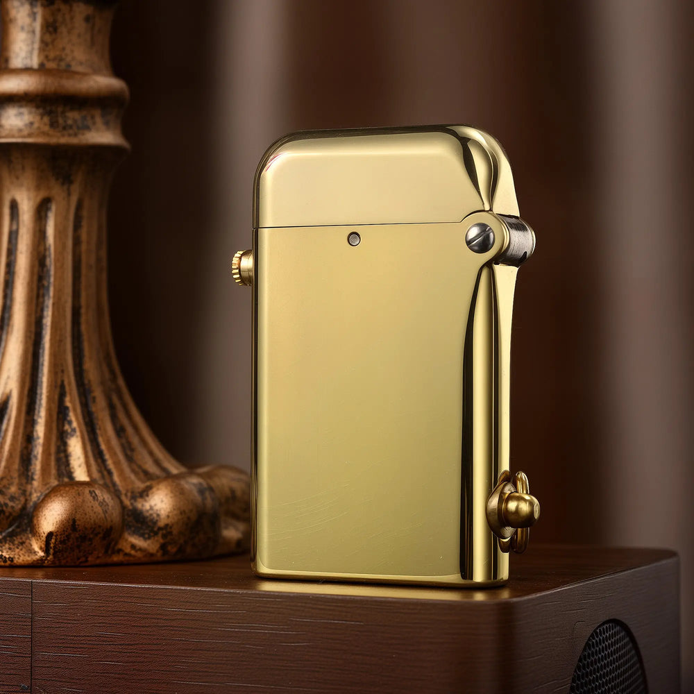 A detailed close-up of the closed Gen 2 Double Claw lighter in a glossy brass finish, standing on a dark wood surface next to a vintage lamp base.