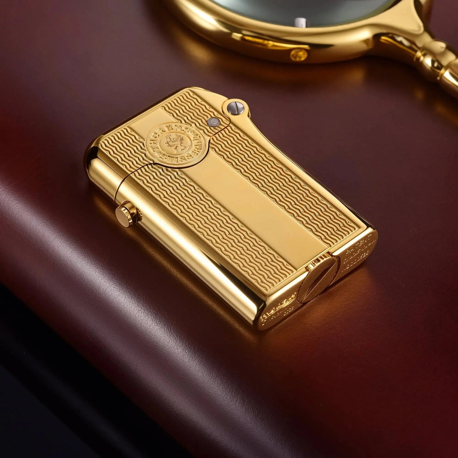 A vertical view of a gold-finished Thorens Gen 3 single claw lighter, showcasing the spaced water ripple engraving and the central Thorens Swiss Brand logo medallion.