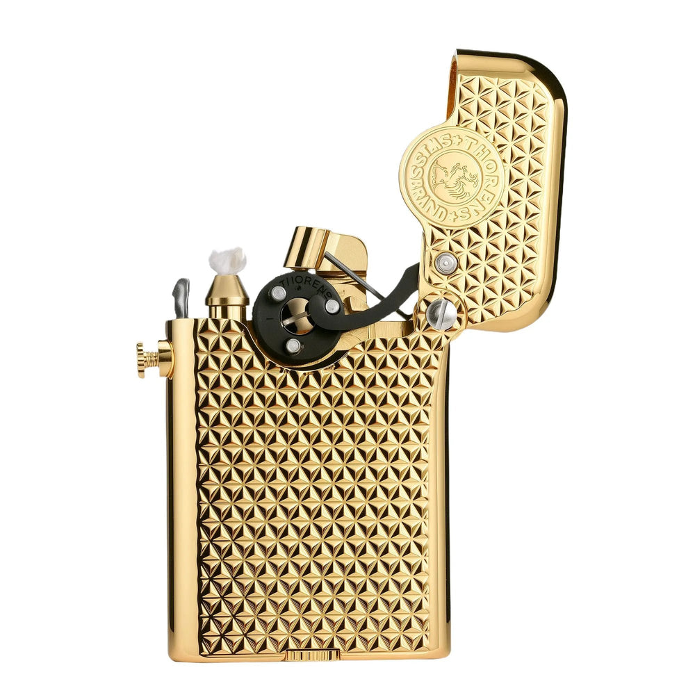 An open gold Thorens Gen 3 mechanical lighter showcasing the single claw ignition mechanism, a white wick, and a detailed diamond grid brass body.