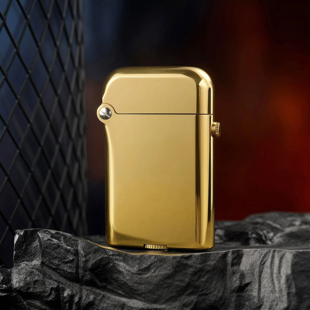 A Thorens Gen 3 Single Claw brass finish lighter with a high-gloss polished surface, standing on a dark volcanic rock base with a modern mesh background.