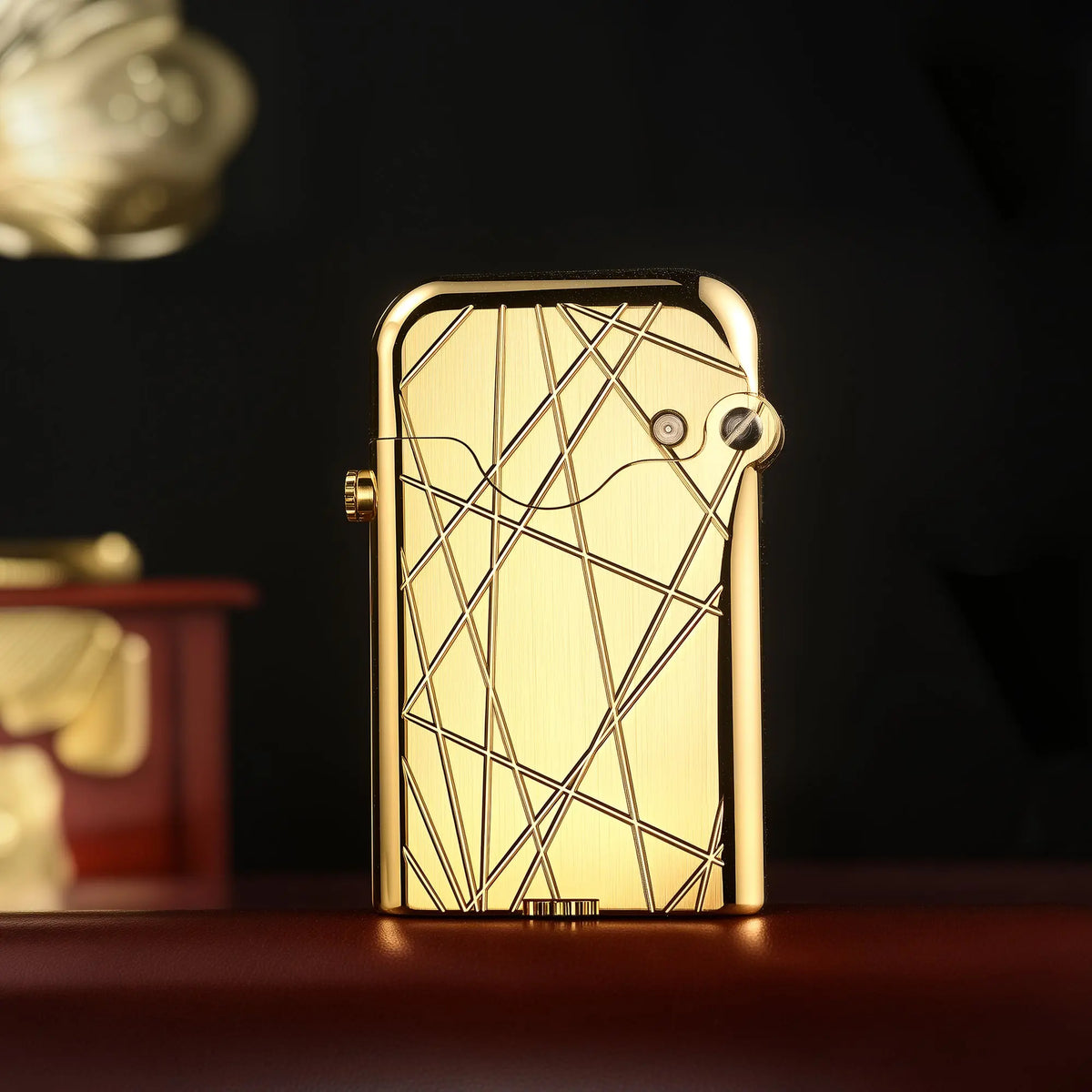 An upright Thorens Gen 3 Single Claw lighter featuring a brushed gold finish with an asymmetric modern grid pattern against a dark, elegant background.