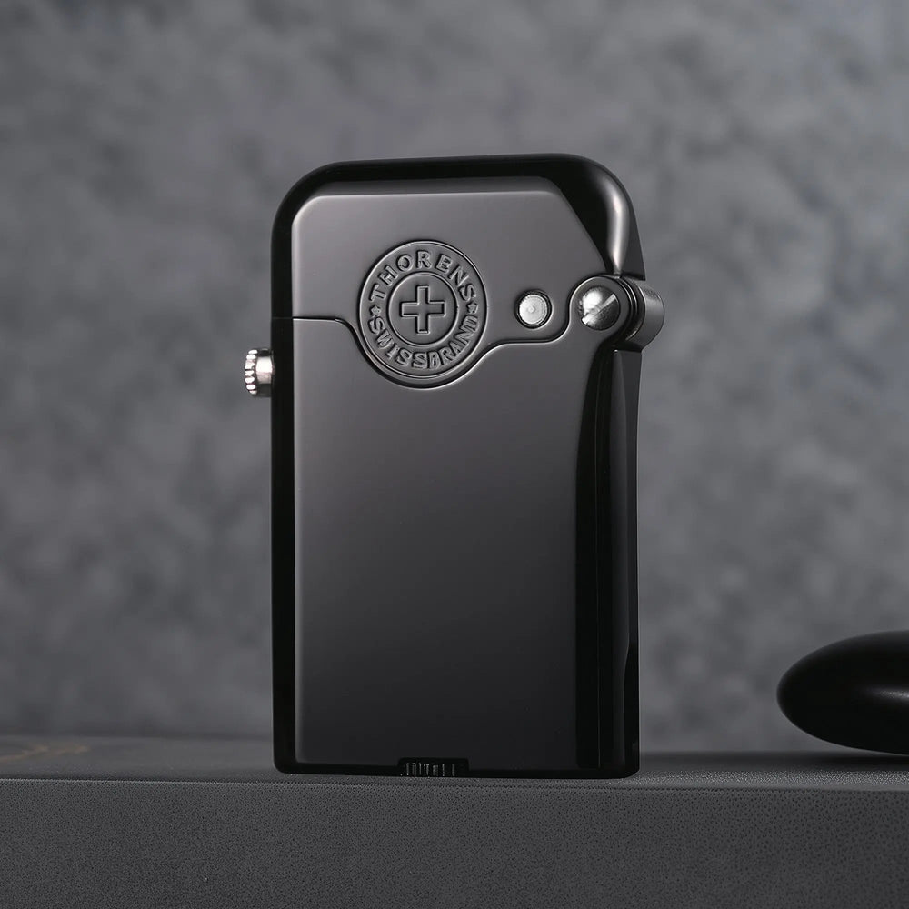 Sleek, glossy black Thorens Gen 3 single-claw lighter featuring an embossed Thorens Swiss Brand emblem and side ignition button, set against a dark textured background.