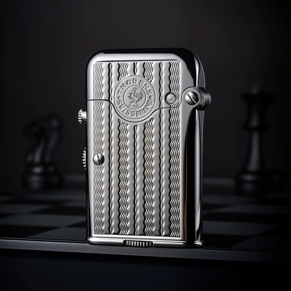 A vertical view of a silver Thorens Gen 7 TELEFLAM lighter featuring a vertical water ripple engraving and heritage emblem on a dark chessboard background.