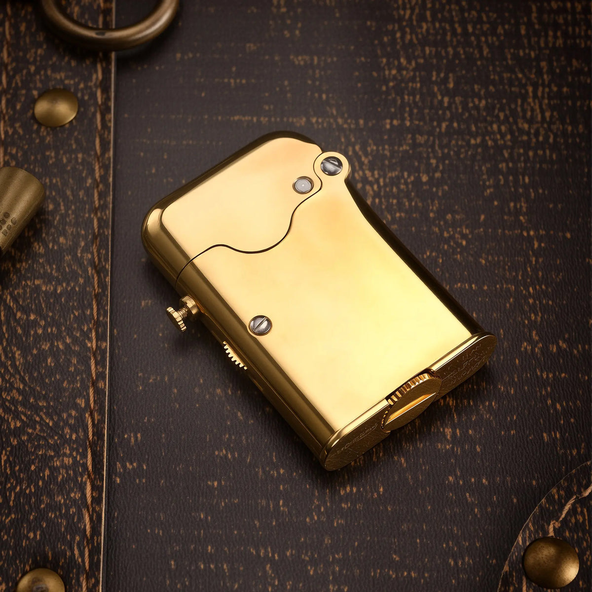 A glossy brass Thorens Gen 7 Teleflam lighter resting on a dark textured surface, showcasing its single claw mechanism and refined heritage craftsmanship.