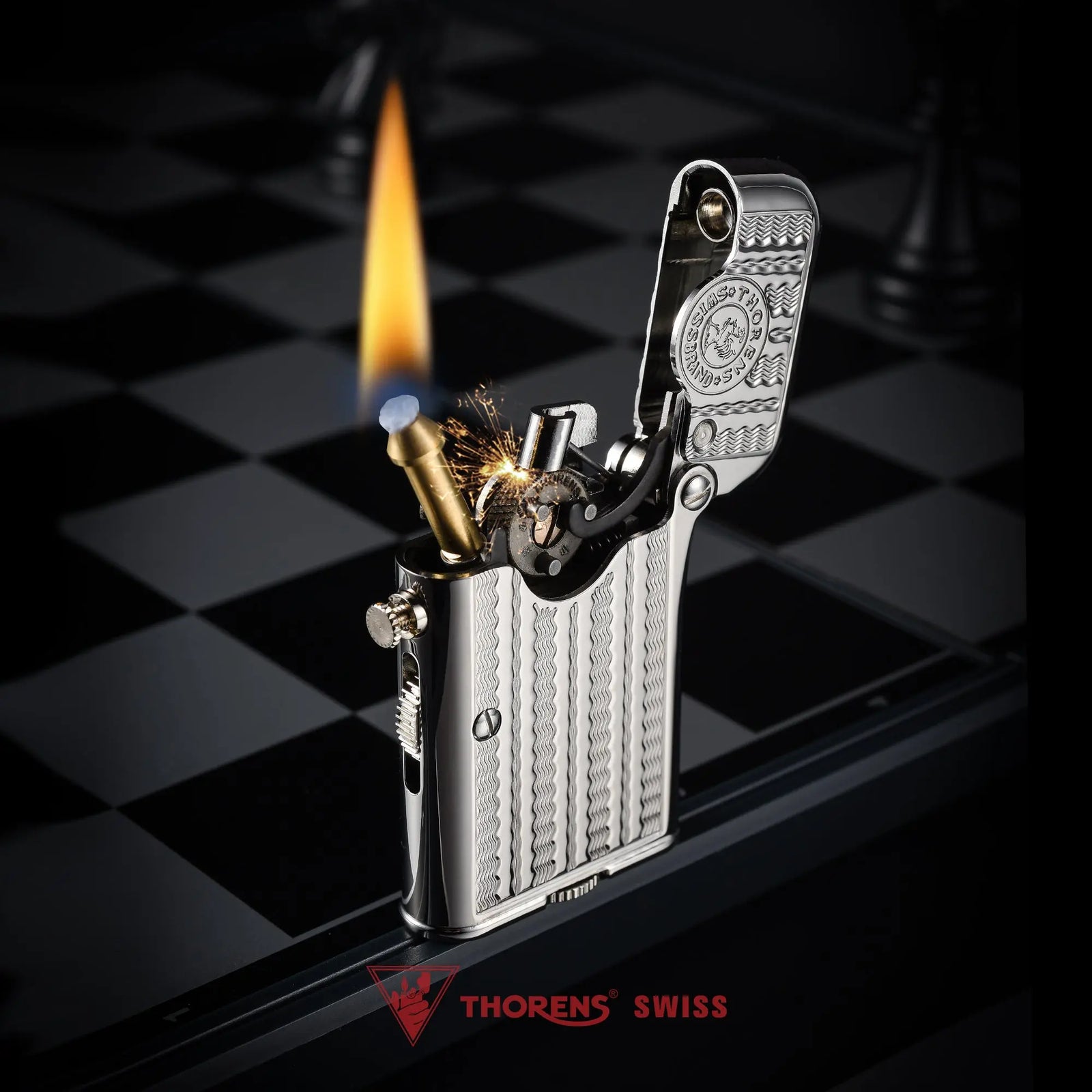 A silver Thorens Gen 7 TELEFLAM lighter ignited with a bright flame, showcasing the water ripple engraving and mechanical single claw on a chessboard.