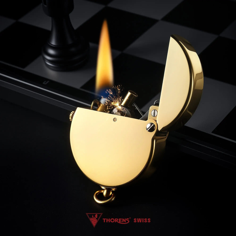 A Thorens Gen 8 Double Claw lighter in glossy brass captured during ignition, showing a steady flame and mechanical sparks against a dark chessboard backdrop.