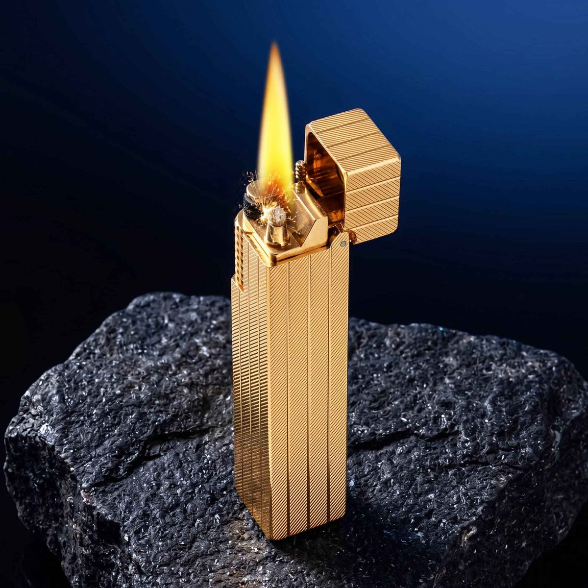 Thorens rectangular lighter with gold diagonal pattern shown open and ignited, highlighting flame, spark, side ignition wheel, and textured surface pattern.