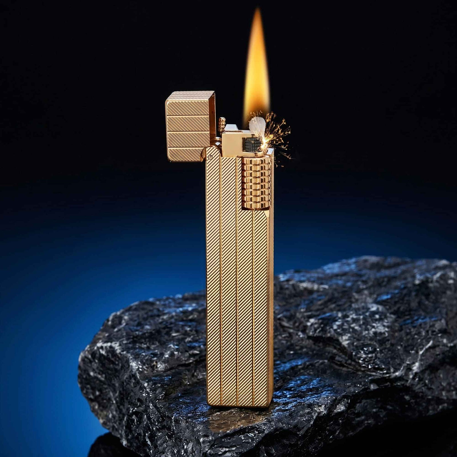 Thorens rectangular lighter with gold diagonal pattern shown open and ignited, highlighting spark, flame, side ignition wheel, and textured surface pattern.