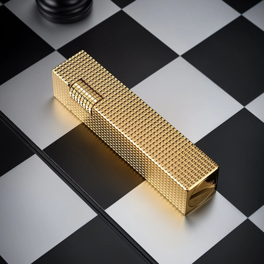 Angled view of a gold small square textured Thorens side-slip rectangular lighter on a black and white checkerboard surface