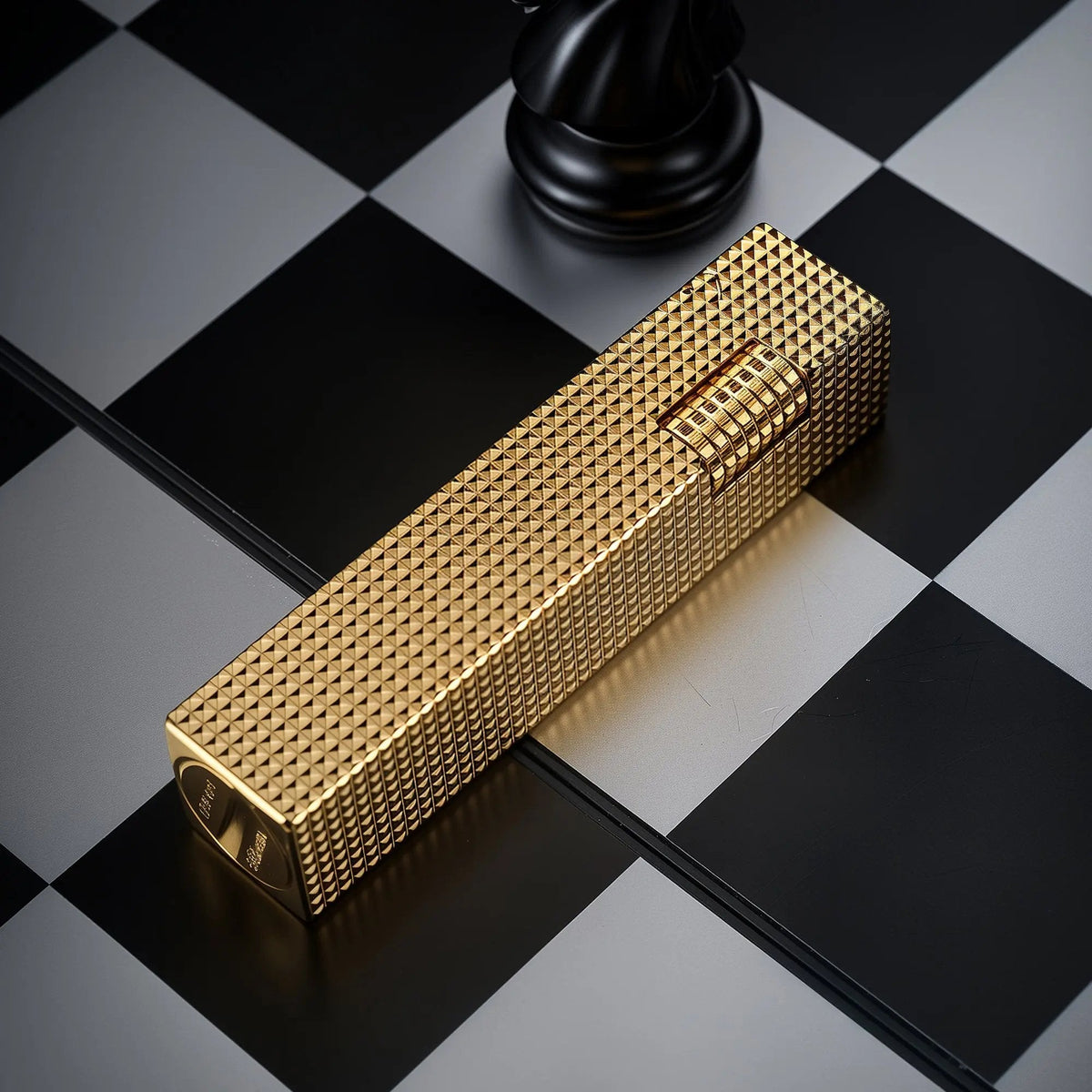 Gold small square textured Thorens side-slip rectangular lighter on a black and white checkerboard surface