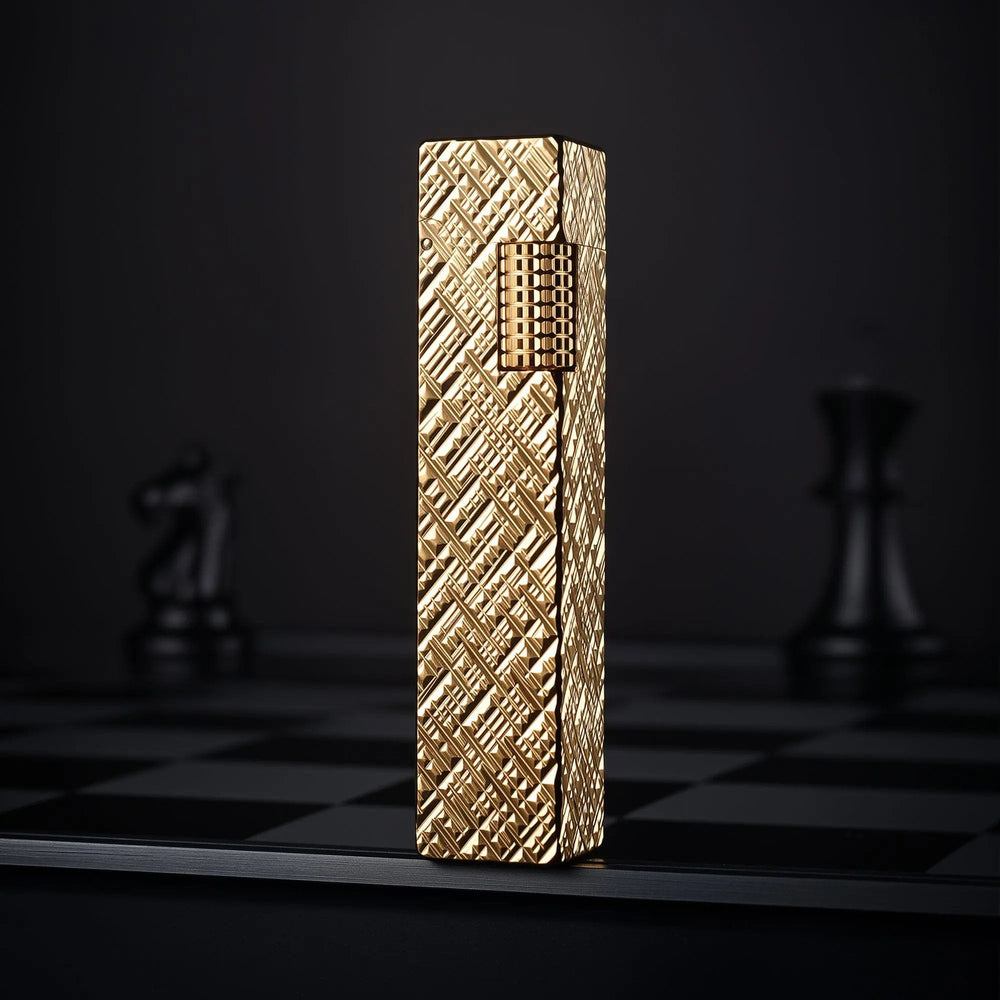 Gold carved rectangular Thorens side-slip lighter standing upright on a dark checkerboard surface