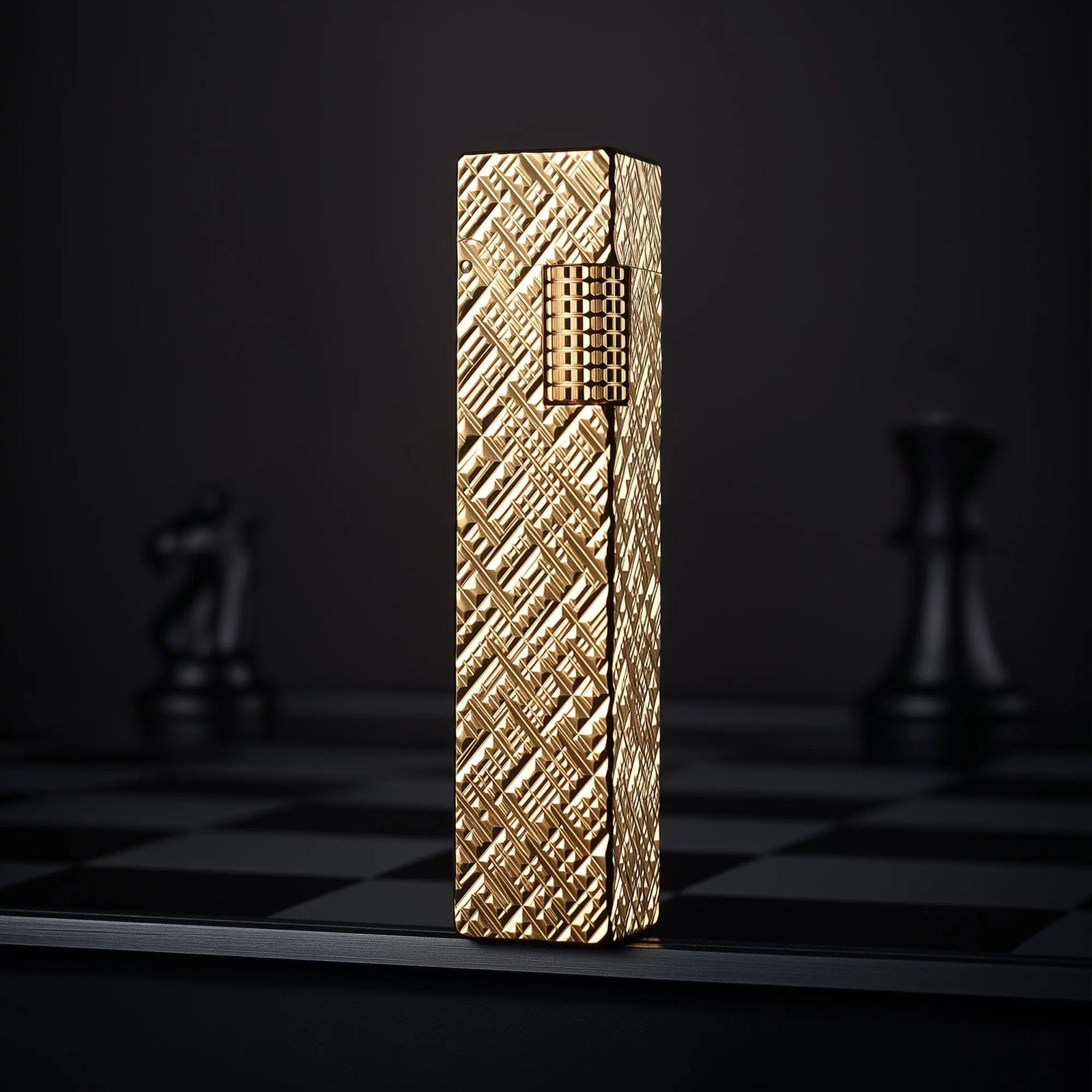 Gold carved rectangular Thorens side-slip lighter standing upright on a dark checkerboard surface