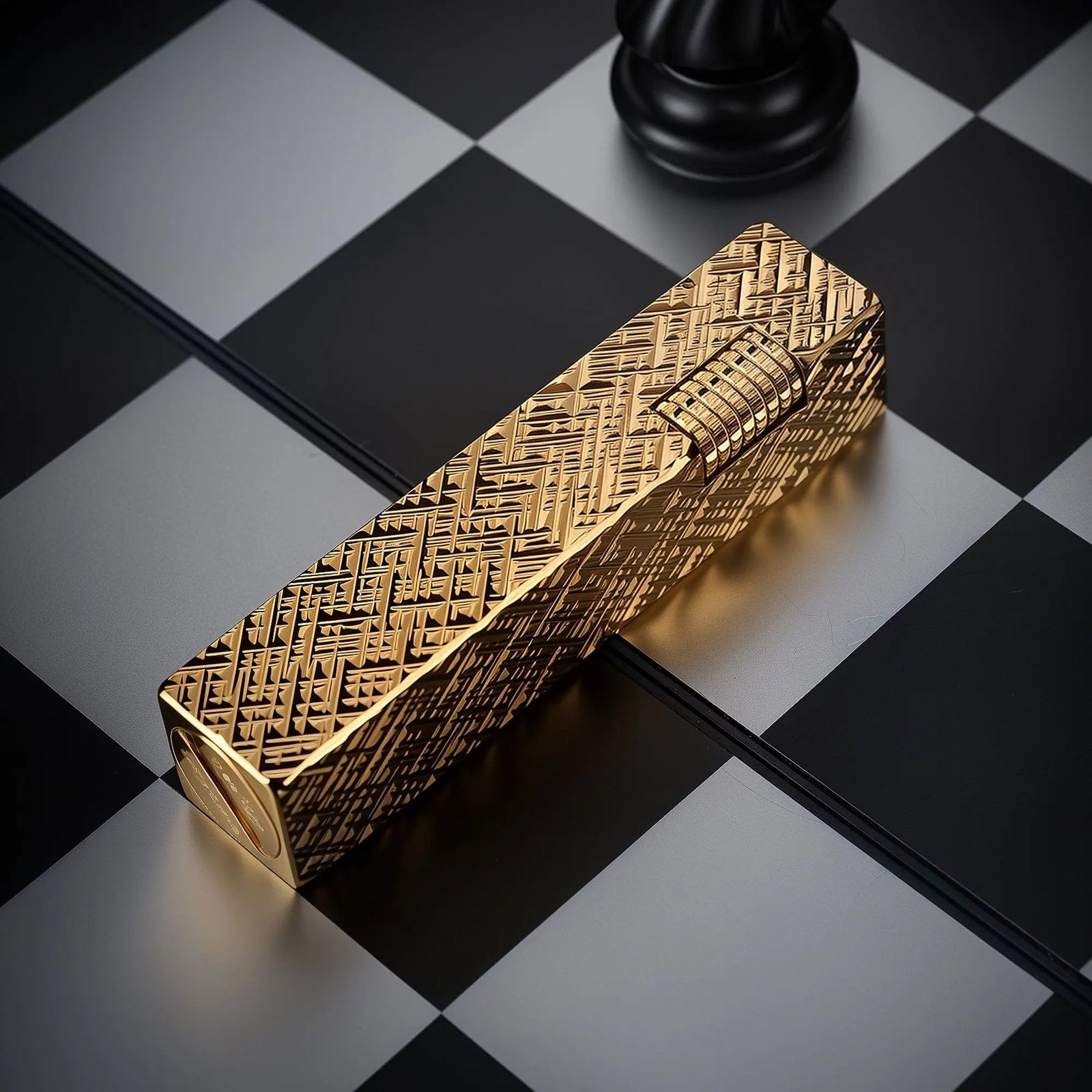 Gold carved rectangular side-slip Thorens lighter on a black and white checkerboard surface