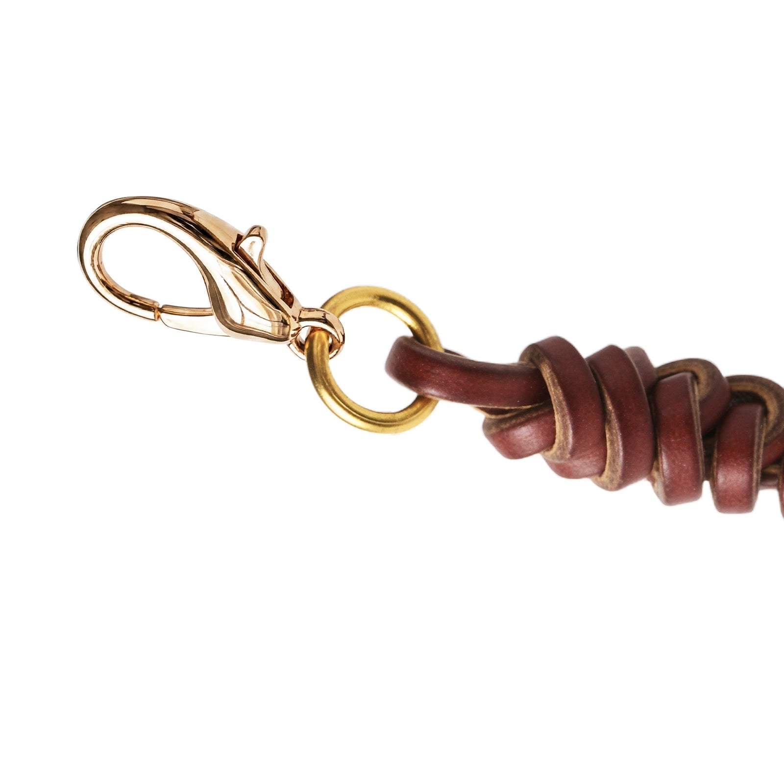 Handwoven cowhide leather charm with braided strap and polished metal clasp and ring, highlighting natural leather texture and fastening detail.