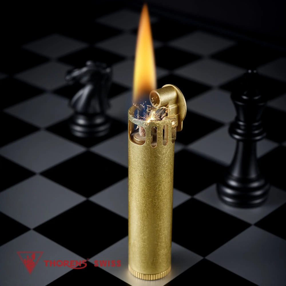 An ignited Ignis Tower brass lighter showing a tall, steady flame and bright ignition sparks, set against a dark chessboard background with a black knight piece.