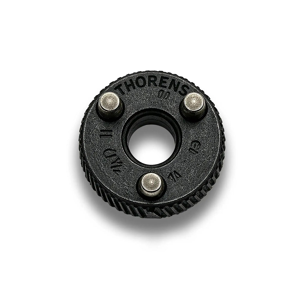 Close-up of a matte black Thorens flint wheel, highlighting the textured industrial finish and the precision mounting pins that ensure seamless engagement with the lighter's internal claw mechanism.