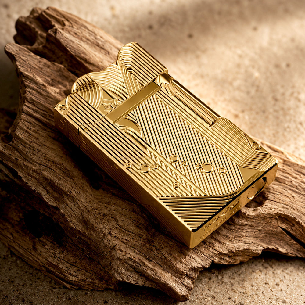 A stunning gold Thorens Mermaid lighter lying on a black and white chessboard, showcasing the intricate linework on its side panels and the unique scalloped top edge.