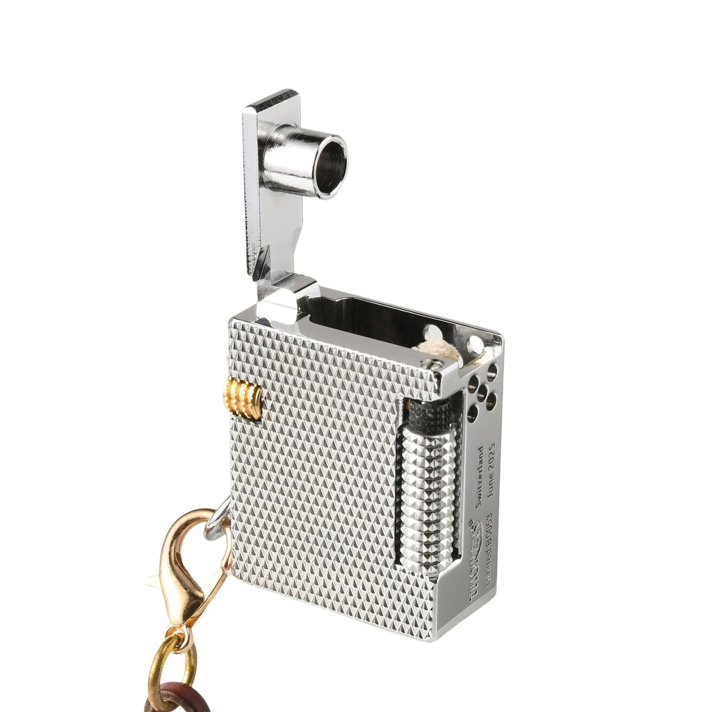A close-up, angled view of the open Thorens Mini Cube Silver Mesh lighter, highlighting the lid structure, brass accents, and engraved technical details on the side.