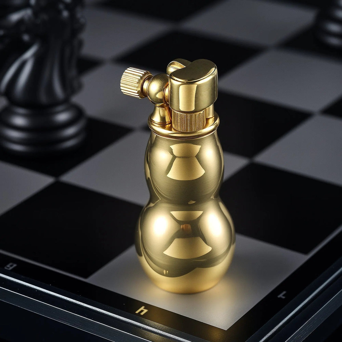 A polished brass Mini Gourd lighter standing on a black and white chessboard, highlighting its unique curved silhouette and vintage mechanical cap.