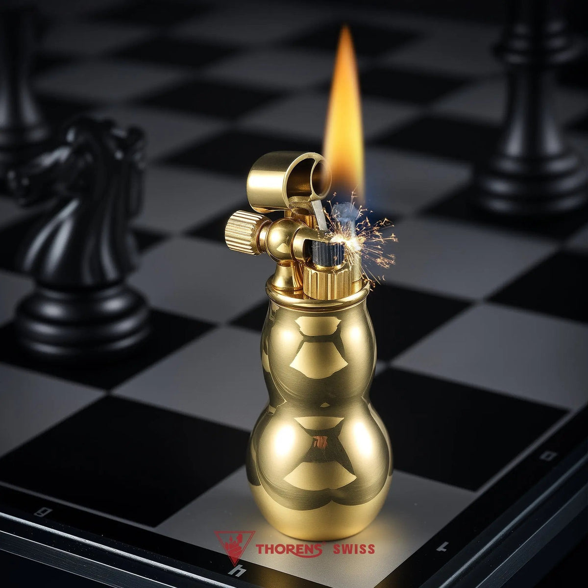A polished brass Mini Gourd lighter ignited on a chessboard, displaying a warm flame, mechanical sparking, and the Thorens Swiss brand logo.