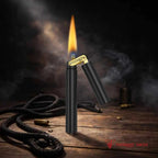 A matte black Thorens Nunchaku lighter standing ignited on a rustic wooden table. The image features a bright, steady flame and wisps of smoke against a moody, dark workshop background, emphasizing its rugged "trench lighter" aesthetic.