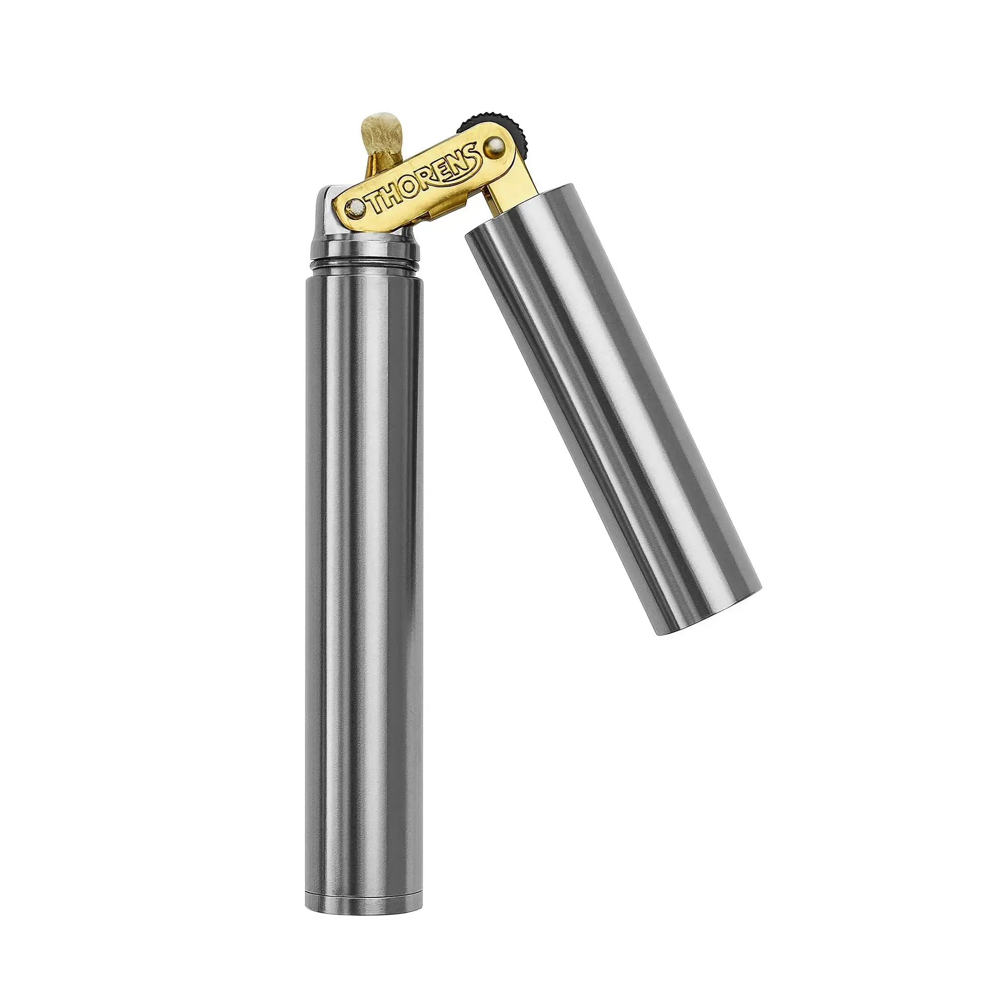 A Thorens Nunchaku lighter in silver chrome shown with the protective cap removed, revealing the brass mechanical assembly, the signature Thorens engraving, and the high-quality cotton wick.