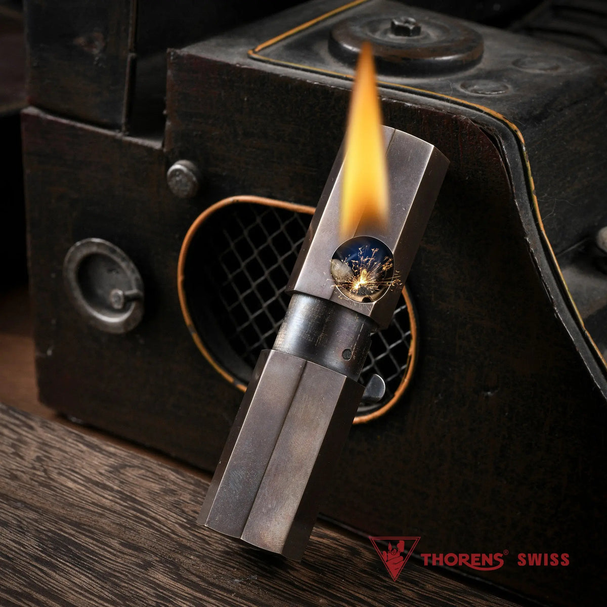 The Octagon Trigger Glossy lighter ignited with a steady flame, showcasing the mechanical ignition sparks and smooth antiqued brass finish.