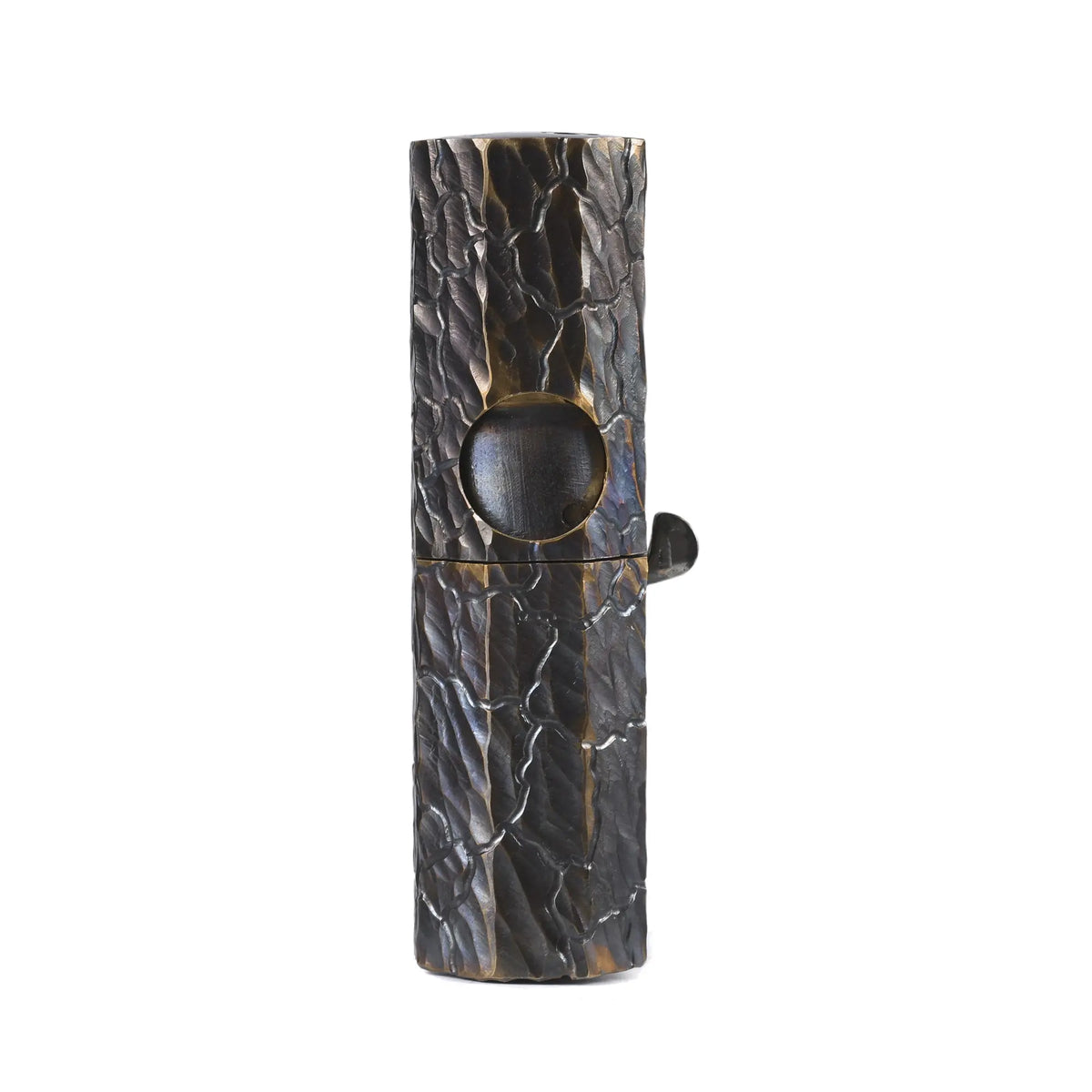 Front studio shot of an Octagon Trigger lighter featuring hand-carved earth fissure texture on antiqued brass with a unique side lever.